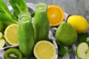 Healthy smoothie with kale in bottles on table