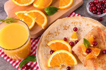 Delicious pancakes with orange and cranberry on plate