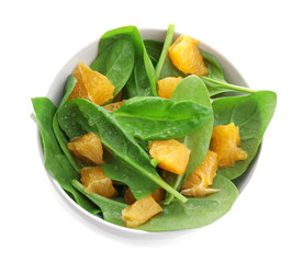 Plate of salad with spinach and orange  on white background