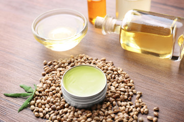Composition with hemp lotion, oil and seeds on wooden background