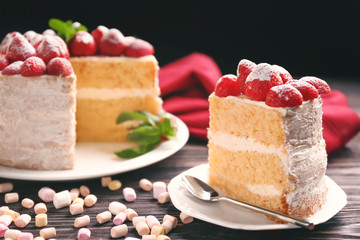 Slice of delicious cake decorated with strawberries on white plate