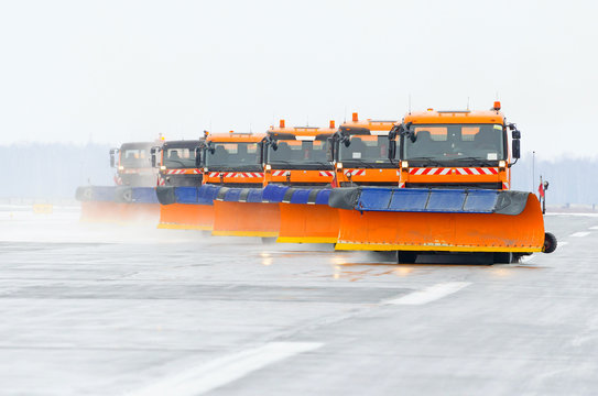 Snowplows In The Work On The Runway At The Airport