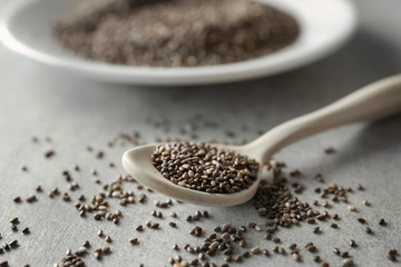 Chia seeds in spoon on grey background