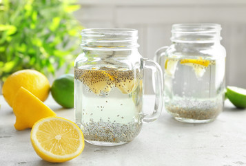 Mason jars with chia seeds, lemon and water on kitchen table