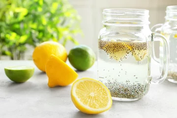 Foto auf Acrylglas Einmachglas mit Chiasamen, Zitrone und Wasser auf dem Küchentisch © Africa Studio