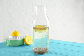 Chia seeds in bottle of water on kitchen table