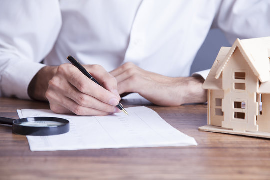 businessman hand document and house model