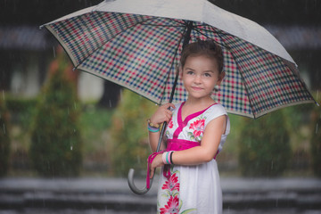 Little girl with umbrella in a rainy day