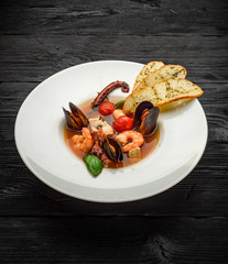 Soup with seafoods decorated with croutons