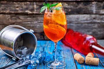 Spritz Aperol cocktail in wine glass on rustic wooden background