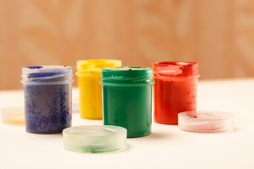 Open small paint jars on a table, closeup shot