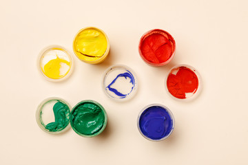 Open small paint jars on a table, selective focus, top view