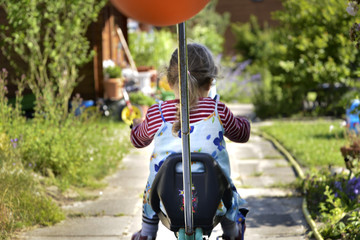 Kind spielt im Garten Dreirad