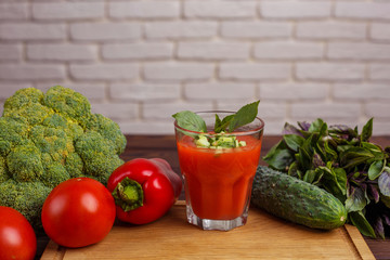 Diet concept, healthy lifestyle, low calorie food. Tomato smoothie with basil and cucumber. Detox and dietary eating with ingredients on wooden table