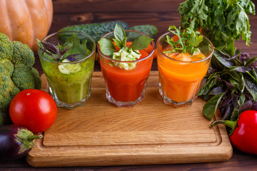 Diet concept, healthy lifestyle, low calorie detox and dietary food. Set of blended vegetable smoothies in glasses with ingredients on kitchen table, free space