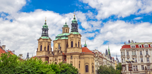 Fototapeta na wymiar Baroque church of St. Nicholas in Malá Strana quarter in the romantic Prague under blue sky. Panoramic of the old city of the hundred towers on a summer day in the capital of the Czech Republic.