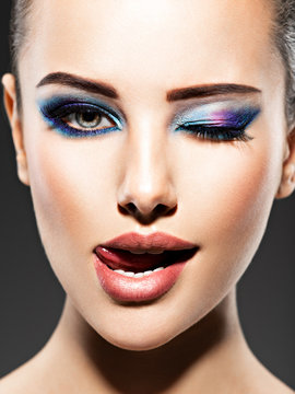 Beautiful face of an young woman with blue makeup of eyes