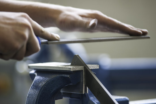 Handwerker feilt Metall, Werkst&uuml;ck im Schraubstock, Nahaufnahme mit Bewegung