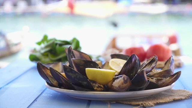 Seafood Dish open and ready mussels on blue table at restaurant with coast sea view in Foca Izmir Turkey.