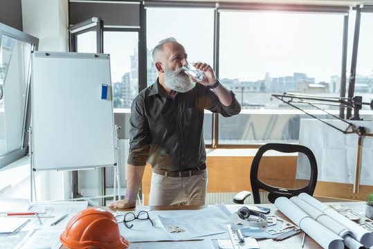 Professional engineer is holding glass of water - Powered by Adobe