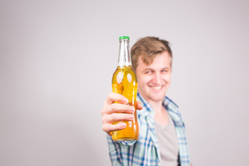 Handsome caucasian man holding a bottle of beer. Background with copy space