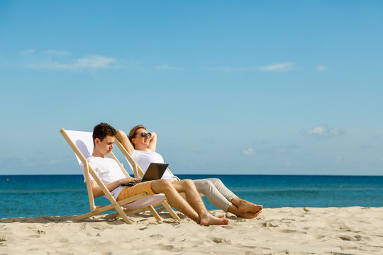 Woman and man relaxing on beach 
