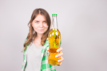 Beautiful woman holding a bottle of beer. Background with copy space