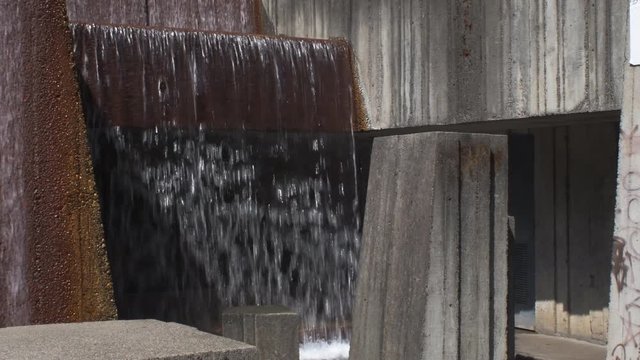 One of the waterfalls at Keller Fountain in Portland, Oregon, with an alcove allowing people to go behind the falling water.