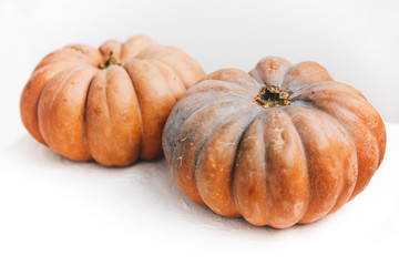 Couple ripe autumn pumpkin on white table on kitchen. Minimalism style,copy space