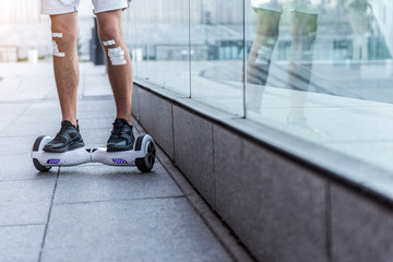 Male legs riding on hoverboard near shop-window