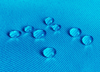 Blue waterproof fabric with waterdrops close up