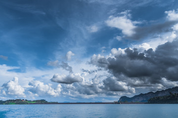 Fototapeta na wymiar White clouds marching above the lake like armies. 