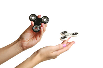 Female hands holding fidget spinner toys on white background