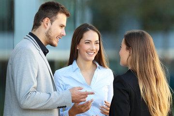 Three executives talking on the street