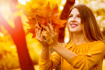 Young beautiful woman in autumn park