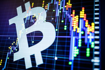 Data analyzing in exchange stock market: the candle chars on display. Analytics price change cryptocurrency BTC to USD (Bitcoin / US Dollar), the most popular pair in the world. Big Bitcoin logo.