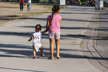 Young girl walking with baby child