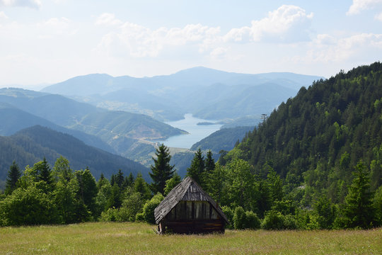 Tara mountain, Serbia. Old cottage in the green field, mountain landscape