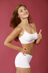 Young beautiful blonde woman in white fitness clothing