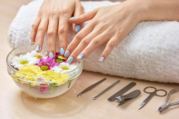 Obraz na płótnie Canvas Female hands receiving spa procedure. Woman hands in beauty salon. Beautiful glass bowl with flowers.