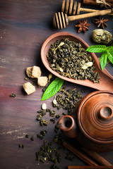 Dry tea leaves in a spoon on an old background