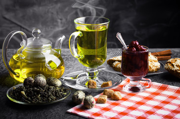 Tea in a cup on a metallic background in a composition with a cookware