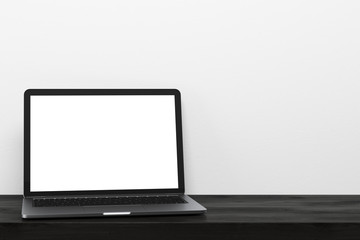 Laptop on a black wooden table, white wall