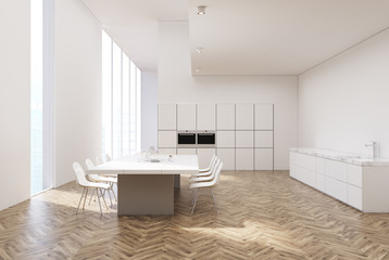 White kitchen with a table, ovens, toned