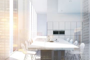 White kitchen with a table, ovens close up, double