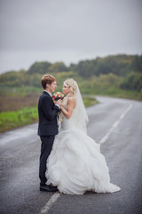 Wedding concept. Bride and groom embracing on road. One way to future	