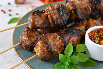 Homemade pork shish kebab with tomato sauce on a concrete background