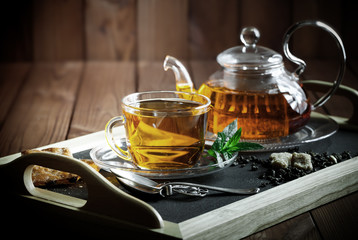 Tea in a cup on a metallic background in a composition with a cookware