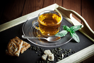 Tea in a cup on a metallic background in a composition with a cookware