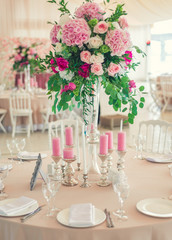 a reflective table at a wedding banquet, a table with candles, flowers and a beautiful tableware